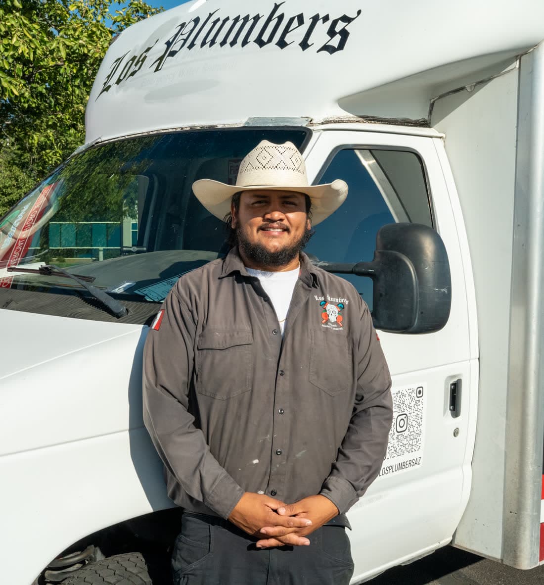 A Los Plumbers plumber standing in front of a branded service truck in Mesa